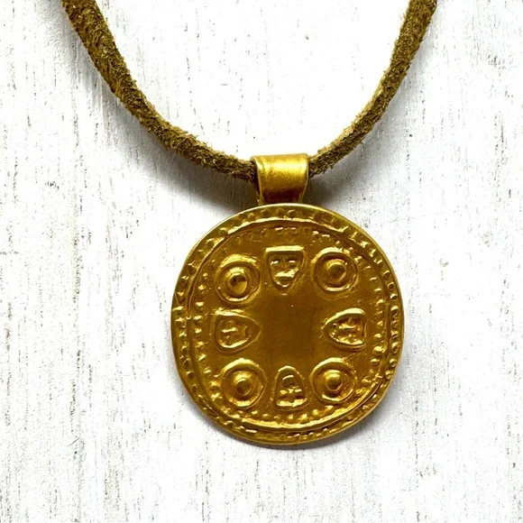 Mayan design gold tone pendant purchased in Costa Rica, on golden suede cord